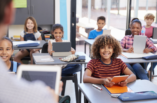 Class of middle school students smiling at their teacher