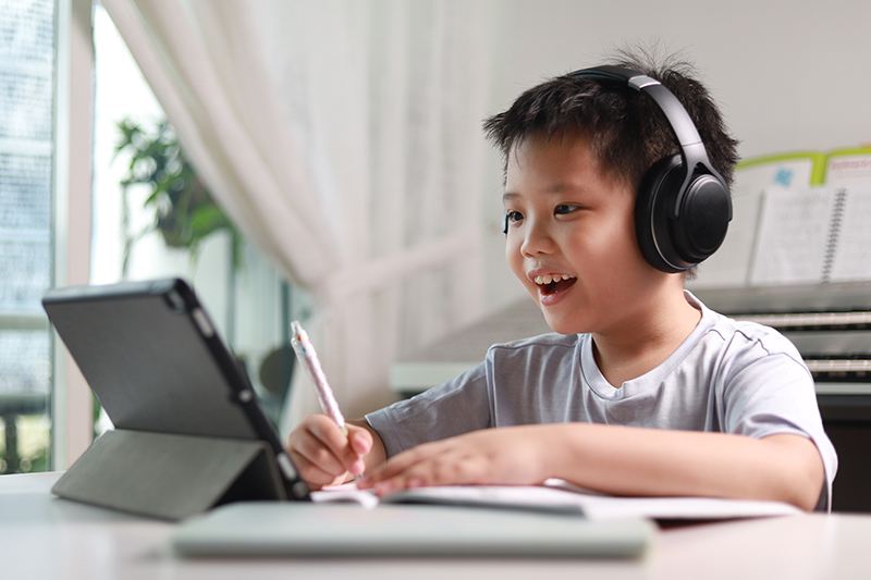 Elementary school student using a stylus and tablet