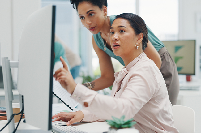 Two colleagues looking at a monitor and having a discussion